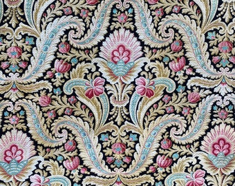 Può includere: Uno sfondo nero con un motivo paisley dorato e rosa. Il motivo presenta intricati disegni floreali e volute.