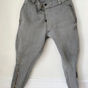 May include: A pair of gray riding breeches with a zipper at the bottom of each leg.