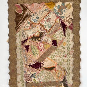 May include: A vintage patchwork quilt with a brown lace border. The quilt is made of various fabrics, including velvet, silk, and brocade. The fabrics are in shades of pink, green, brown, and gold. The quilt is hand-stitched and has a unique and intricate design.