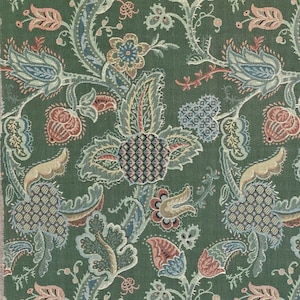 May include: A green fabric with a repeating pattern of stylized flowers and leaves in shades of blue, red, yellow, and brown.