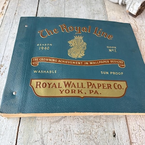 May include: A vintage wallpaper catalogue, "The Royal Line", from 1940. The teal cover features gold lettering and a lion emblem. It's labelled "Book No. 2" and includes "Royal Wall Paper Co., York, PA."