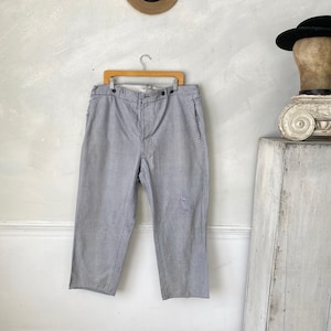 May include: Gray striped pants with a button fly and a single back pocket. The pants have a relaxed fit and are made of a lightweight fabric.