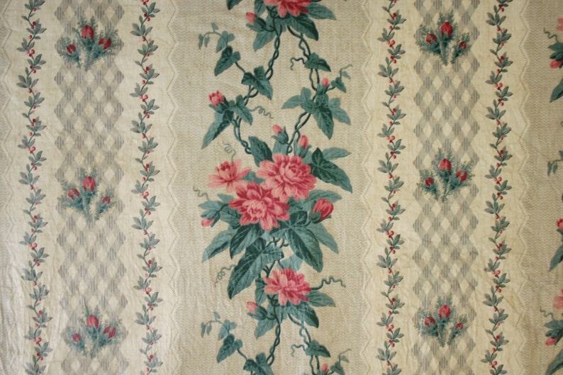 K&ouml;nnte beinhalten: Eine vintage Blumen-Tapete mit einem sich wiederholenden Muster aus rosa Rosen, gr&uuml;nen Bl&auml;ttern und kleinen roten Beeren. Der Hintergrund ist hellbeige mit einem dezenten Rautenmuster.