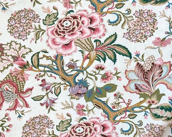 Könnte beinhalten: Ein weißer Stoff mit einem sich wiederholenden floralen Muster. Das Muster zeigt rosa, rote, grüne und blaue Blumen mit filigranen Details. Der Hintergrund ist cremefarben.