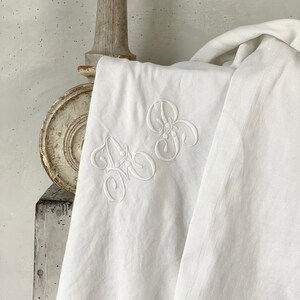 May include: White linen tablecloth with embroidered initials "A & B" in a delicate floral design.