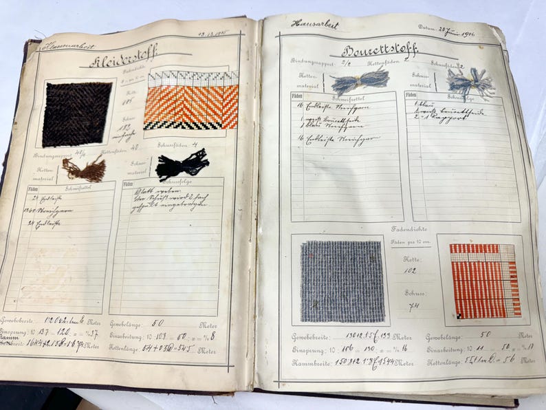 May include: A vintage fabric sample book with handwritten notes and fabric swatches. The book includes samples of black and white, orange and black, and gray and white fabrics. The book is labeled "Fleischstoff" and "Doucette Stoff".