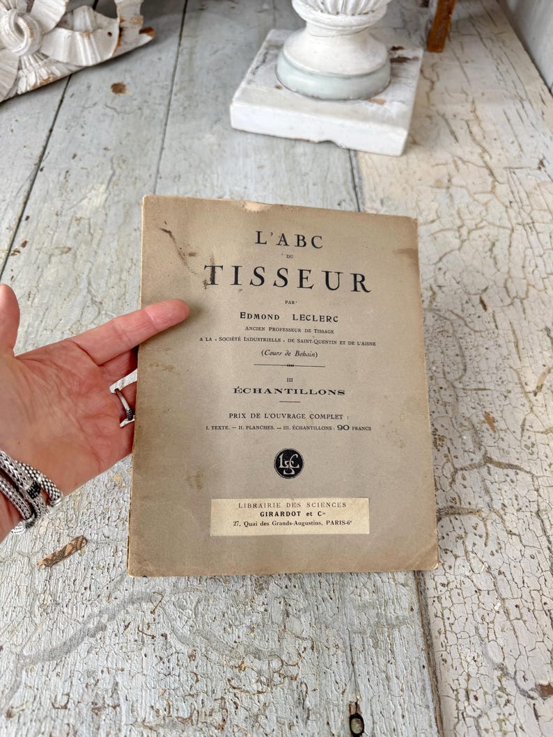 Pode incluir: Um livro vintage intitulado "L'ABC TISSEUR" de Edmond Leclerc, antigo professor de tecelagem. O livro &eacute; publicado por Librairie des Sciences Girardot et C, 27 Quai des Grands Augustins, Paris.