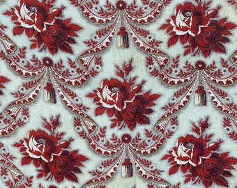 Può includere: Un tessuto bianco con un motivo ripetuto di rose rosse e fiocchi. Le rose hanno centri bianchi e i fiocchi sono legati con nappe.