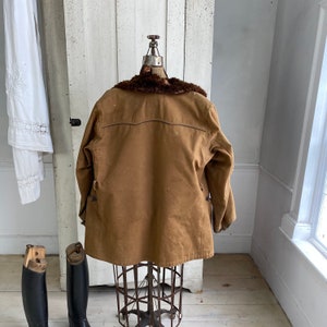 May include: A brown corduroy jacket with a fur collar. The jacket is on a mannequin and is displayed against a white background.