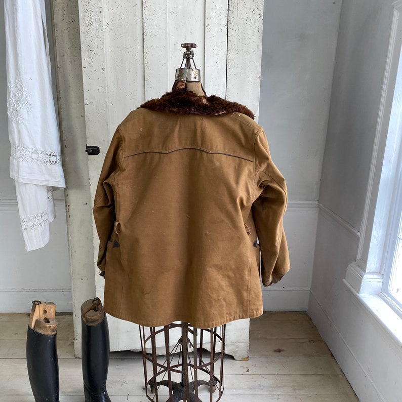 May include: A brown corduroy jacket with a fur collar. The jacket is on a mannequin and is displayed against a white background.