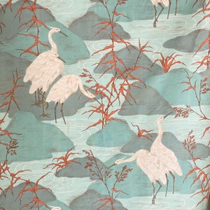 May include: A fabric with a repeating pattern featuring white herons, stylized mountains, and flowing water in shades of teal, gray, and rust. The design evokes a serene, natural landscape.