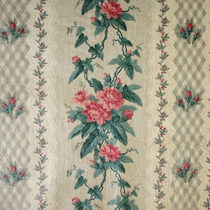 K&ouml;nnte beinhalten: Ein Vintage-Blumenstoff mit einem sich wiederholenden Muster aus rosa Rosen und gr&uuml;nen Bl&auml;ttern auf cremefarbenem Hintergrund. Der Stoff hat ein dezentes Rautenmuster in Grau und Wei&szlig;.