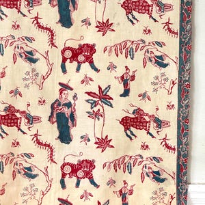 Könnte beinhalten: Cremefarbener Stoff mit einem sich wiederholenden Muster aus roten Tigern, Figuren und botanischen Elementen. Das Design umfasst blaue Akzente und einen Rand mit floralen Motiven. Der Stoff hat eine Vintage-Ästhetik.