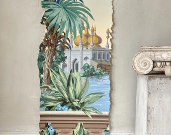 May include: A torn piece of wallpaper featuring a detailed landscape scene. The design includes palm trees, a body of water, and a building with golden domes. The color palette consists of greens, blues, and beige tones, creating a vintage aesthetic.