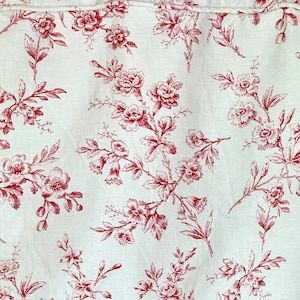May include: White fabric with a red floral pattern. The pattern features small, delicate flowers and leaves.