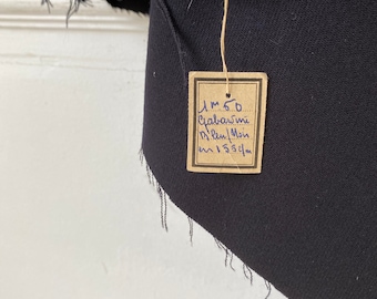 May include: A black fabric swatch with a brown tag that reads "1.m 5.0  Собраними  12.len/1.m  cm 1.53 cm".