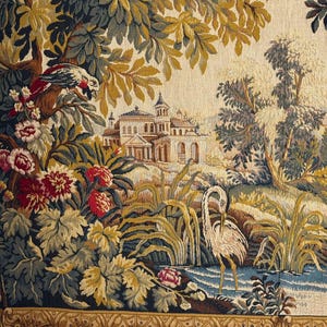 May include: A detailed tapestry depicting a serene landscape with a classical building, lush foliage, and a bird perched on a branch. The scene includes a body of water with a heron. The color palette features greens, blues, and earth tones.