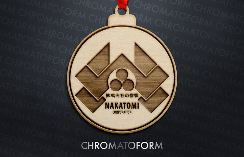 K&ouml;nnte beinhalten: Runder Weihnachtsbaumschmuck aus Holz mit geometrischem Design und dem Text "NAKATOMI CORPORATION". Der Schmuck hat ein rotes Band zum Aufh&auml;ngen. Das Wort "CHROMATOFORM" steht unten. Das Design enth&auml;lt japanischen Text.
