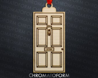 May include: Wooden ornament shaped like a door, featuring the address "221B" above the door knocker. The word "LETTERS" is visible below the knocker. A red ribbon is attached for hanging. The ornament is made of light-colored wood.