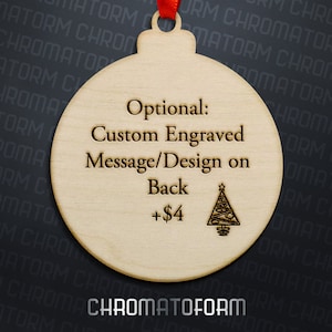 K&ouml;nnte beinhalten: Ein h&ouml;lzerner Weihnachtsschmuck mit rotem Band. Der Schmuck tr&auml;gt den Text "Optional: Custom Engraved Message/Design on Back" und einen kleinen eingravierten Weihnachtsbaum. Der Schmuck ist hellbraun.