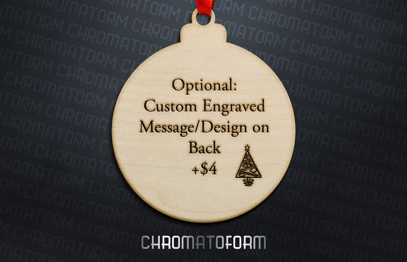 K&ouml;nnte beinhalten: Ein h&ouml;lzerner Weihnachtsschmuck mit rotem Band. Der Schmuck tr&auml;gt den Text "Optional: Custom Engraved Message/Design on Back" und einen kleinen eingravierten Weihnachtsbaum. Der Schmuck ist hellbraun.