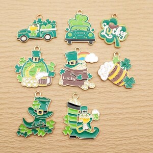 May include: Assortment of 10 gold-tone metal charms with green enamel. Charms feature St. Patrick's Day themes, including leprechauns, shamrocks, beer mugs, and a truck with a pot of gold.
