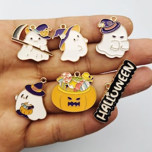 May include: A collection of six enamel charms featuring Halloween themes, including three white ghosts wearing purple witch hats, one ghost holding a scythe, one orange jack-o'-lantern bucket filled with colorful candy, and a black bar with the text HALLOWEEN.