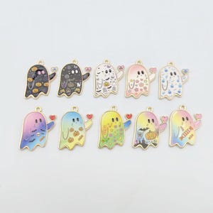 May include: Ten ghost-shaped metal charms with gold-toned edges, each holding a small heart. The ghosts feature various colorful patterns including pumpkins, bats, stars, flowers, and candy, with some designs using gradient color fills and others solid.