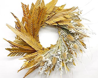 May include: A dried palm leaf wreath with white dried flowers and seed pods.