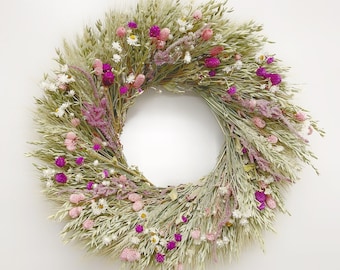 Könnte beinhalten: Ein Trockenblumenkranz mit einer Mischung aus weißen, rosa und violetten Blüten. Der Kranz ist aus getrockneten Gräsern und Blumen gefertigt und perfekt für einen rustikalen oder Landhausstil.