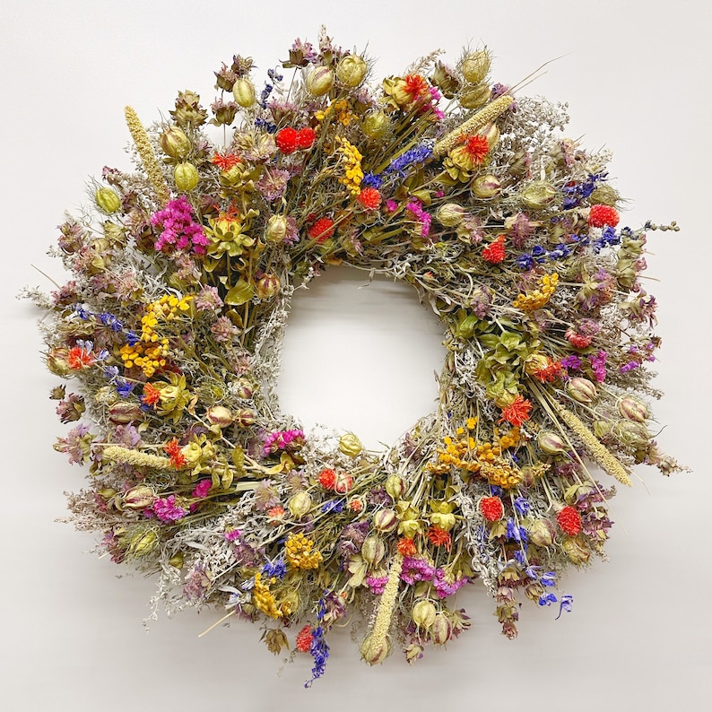 May include: A dried flower wreath featuring a mix of purple, blue, yellow, orange, and red flowers. The wreath is crafted from dried flowers and grasses, adding a touch of natural beauty to any home.