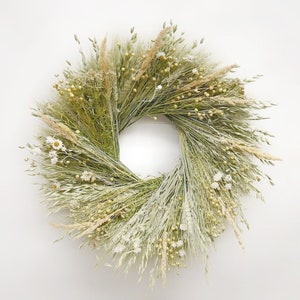 May include: A green and white dried flower wreath with small white flowers and seed pods.