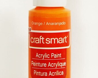 Könnte beinhalten: Eine 59 ml Flasche orangefarbene Acrylfarbe von Craft Smart. Die Flasche ist mit den Worten "Orange / Anaranjado", "craft smart", "Acrylic Paint", "Peinture Acrylique" und "Pintura Acrílica" beschriftet.