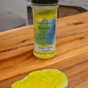 Może przedstawiać: Mały słoik z jasnożółtym materiałem flockującym z etykietą "Flocking Unlimited Flock & Go (1oz) Flocking Fibers and Applicator www.FlockingUnlimited.com Bright Yellow Flocking"