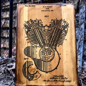 Puede incluir: Una placa de madera con un dibujo en blanco y negro de un motor Harley Davidson patentado. La patente est&aacute; fechada el 30 de octubre de 1923 y el inventor es William S. Harley. El n&uacute;mero de patente es 1.472.068.