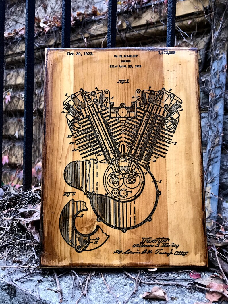 Puede incluir: Una placa de madera con un dibujo en blanco y negro de un motor Harley Davidson patentado. La patente est&aacute; fechada el 30 de octubre de 1923 y el inventor es William S. Harley. El n&uacute;mero de patente es 1.472.068.
