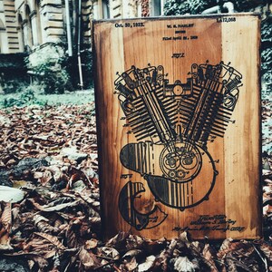 Puede incluir: Una placa de madera con una ilustraci&oacute;n en blanco y negro de una patente de motor Harley Davidson. El n&uacute;mero de patente es 1.472.068 y la fecha es el 30 de octubre de 1923. El texto en la placa dice "W.L. Harley, Inventor, Presentado el 16 de abril de 1920,  No. 2."