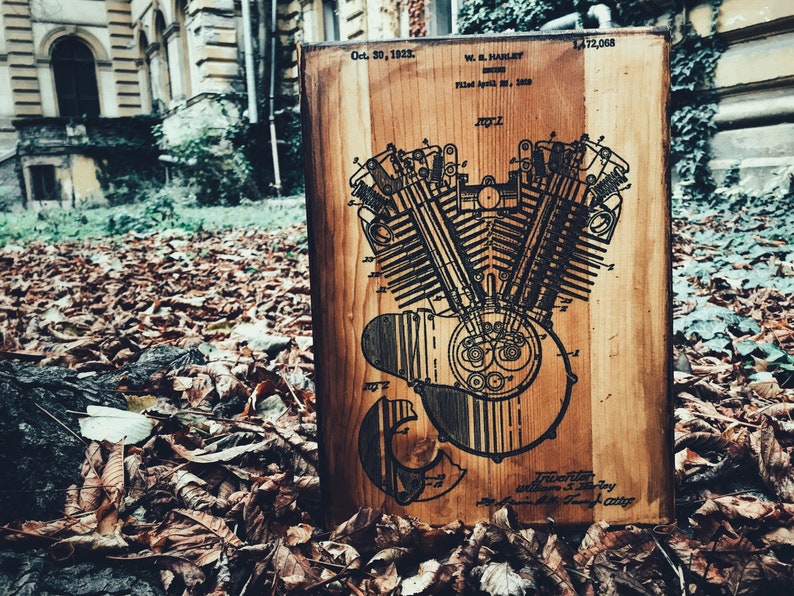 Puede incluir: Una placa de madera con una ilustraci&oacute;n en blanco y negro de una patente de motor Harley Davidson. El n&uacute;mero de patente es 1.472.068 y la fecha es el 30 de octubre de 1923. El texto en la placa dice "W.L. Harley, Inventor, Presentado el 16 de abril de 1920,  No. 2."