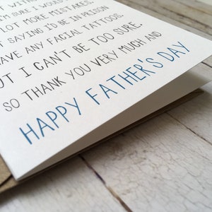 May include: A white card with blue text that reads "Happy Father's Day". The card has a message that reads "Now you're a dad but with my life I'm sure I would make a lot more mistakes. I'm not saying I'd be in prison or have any facial tattoos. But I can't be too sure. So thank you very much and Happy Father's Day."