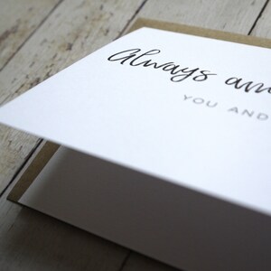 May include: A white card with the text "Always and forever, you and me" written in black cursive script.