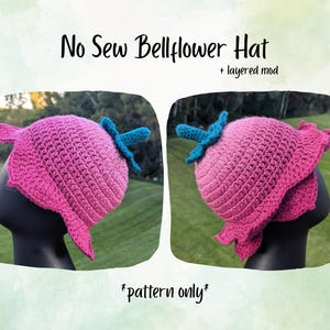 May include: A pink crocheted bellflower hat with a blue stem and leaves. The hat is displayed on a black mannequin head. The text "No Sew Bellflower Hat" and "+ layered mod" are at the top. The text "*pattern only*" is at the bottom.