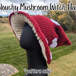 Könnte beinhalten: Ein schlaffer Pilz-Hexenhut mit dunkelroter Außenseite, weißen gehäkelten Punkten und cremefarbener Unterseite. Der Text Slouchy Mushroom Witch Hat und *pattern only* ist sichtbar. Diese gehäkelte Kopfbedeckung hat eine breite, schlaffe Krempe.