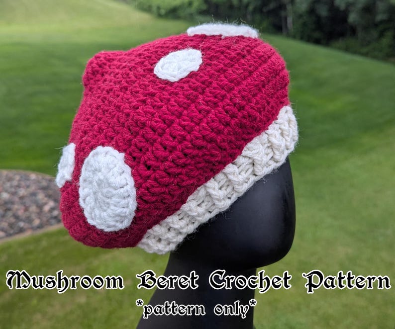 May include: A handmade crochet mushroom beret in a vibrant red with white spots and a cream-coloured brim. The hat is designed to resemble a mushroom. The text on the image reads "Mushroom Beret Crochet Pattern *pattern only*".