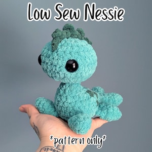 May include: A teal crochet plush toy shaped like a sea monster with large black eyes and a dark green dorsal fin. The text Low Sew Nessie and *pattern only* are displayed in white font with a black outline against the solid background.