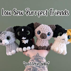 May include: Four crocheted cat plushies with large plastic eyes, including a gray tabby, a black cat with white markings, a light brown Siamese-style cat, and a calico cat. The text reads Low Sew Purrfect Friends and *pattern only*.