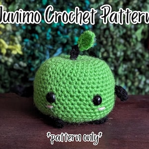 May include: A green crocheted Junimo figure with black eyes, small black limbs, and a single green leaf on top. The text Junimo Crochet Pattern and *pattern only* are visible in the image. The figure has a round body and stitched white accents.
