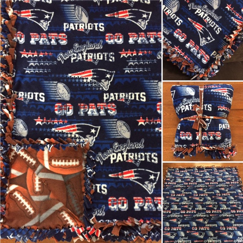 May include: A blue and brown fleece blanket with a New England Patriots theme. The blanket features the team logo, the words "Go Pats", and stars. The blanket is tied with brown ribbon.