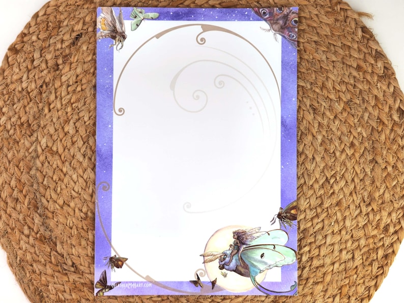 May include: A decorative stationery sheet with a purple watercolor border and illustrations of moths and a fairy riding a moth. The design includes a crescent moon and swirling lines. The stationery is on a woven surface.