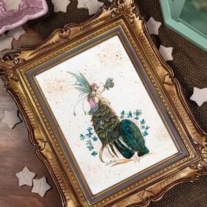 May include: A framed illustration of a fairy with green wings and a pink dress sitting on a bed of green leaves. The fairy is holding a green four-leaf clover. The background is a light brown with white speckles.