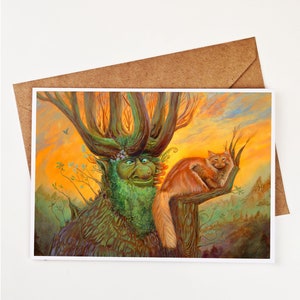 May include: Greeting card featuring a whimsical illustration of a green tree-like creature and a ginger cat perched on a branch. The artwork has a warm color palette with an orange and yellow sunset background. The card is inside a brown envelope.